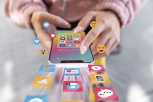 Person interacting with smartphone displaying social media apps and icons, emphasizing social media advertising strategies for Elk Grove businesses.