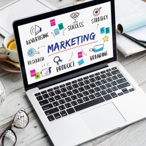 Laptop displaying marketing concepts including advertising, branding, and strategy, relevant to digital marketing growth goals.